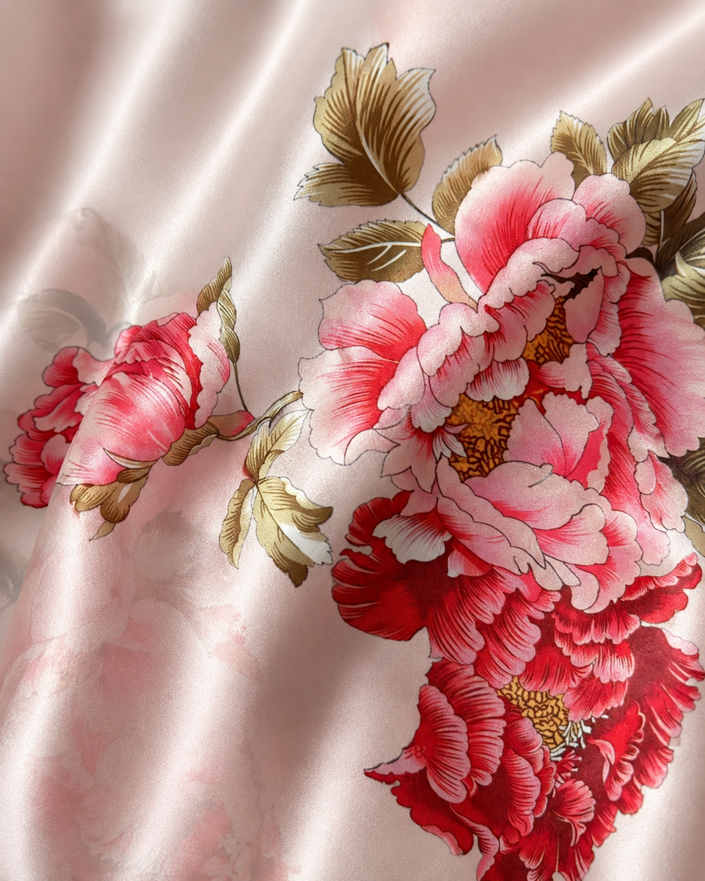 Close-up of blush pink satin-like fabric with red peony floral print