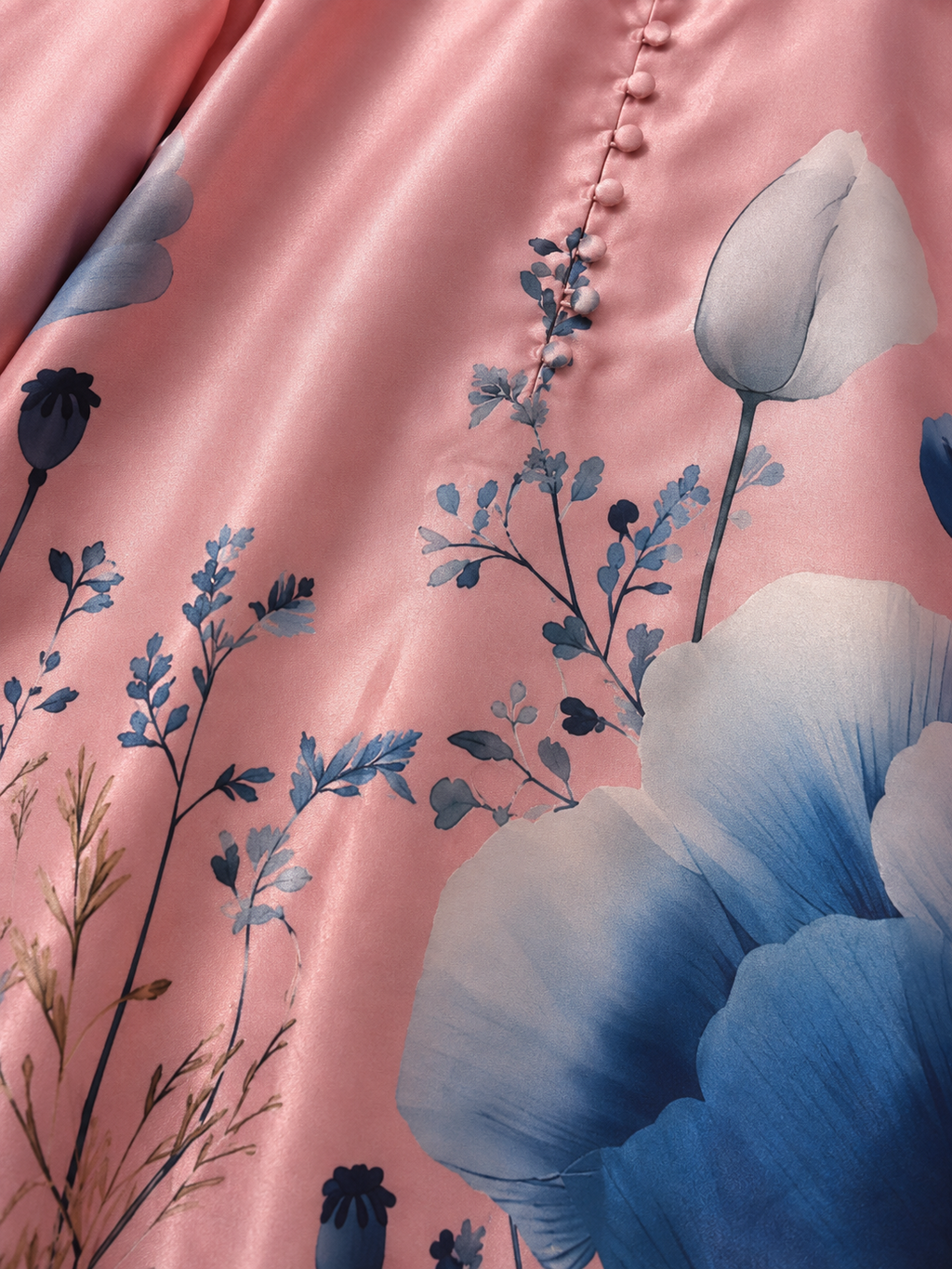 Close-up of blush pink fabric with blue floral print and covered buttons